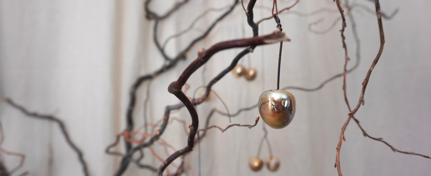 Goldene Keramikkirsche Iskra an Ast hängend